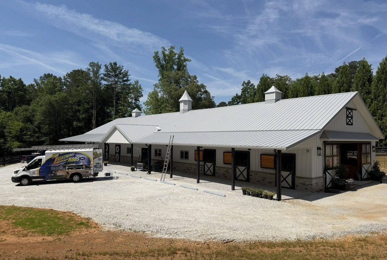 White stable barn with a cupola in open pasture